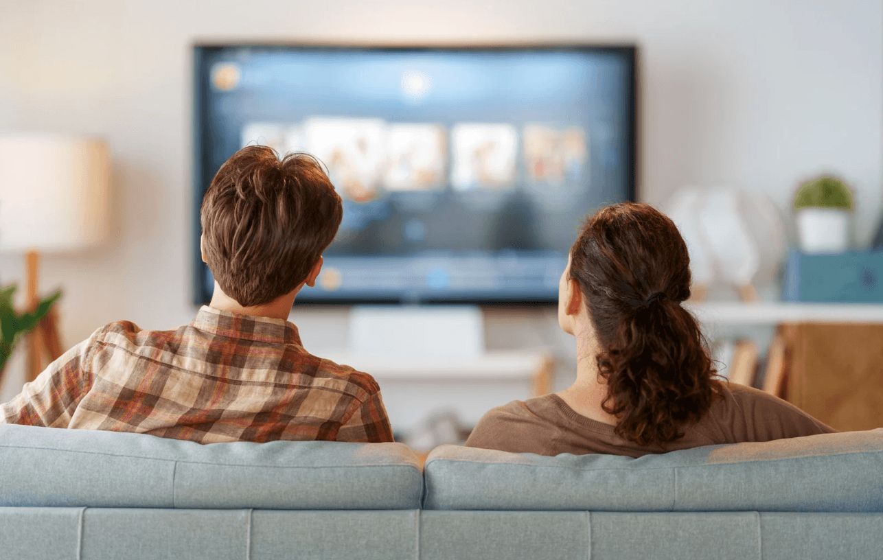 En man och en kvinna kollar på tv